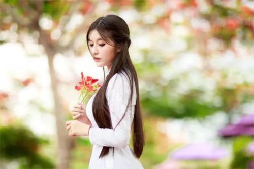 Một chút suy tư, trầm lắng là cảm xúc của bức ảnh nữ sinh cầm hoa phượng khi chụp ảnh áo dài kỷ yếu
