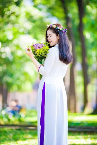 Hình ảnh cô gái mặc áo dài trắng hoặc áo dài đứng dưới tán cây mùa thu, lá vàng rơi